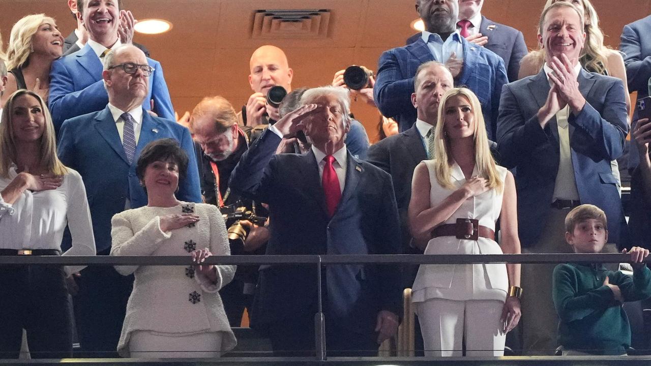 US President Donald Trump stands as US singer-songwriter Jon Baptiste performs the National Anthem. Photo by TIMOTHY A. CLARY / AFP.