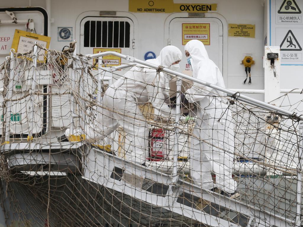 Ship workers help load food onto the Hong Kong flagged cargo ship Chipol Changjiang dressed in full personal protective equipment. Picture: Brendan Radke