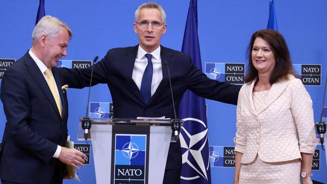 NATO Secretary General Jens Stoltenberg (C) embraces Finnish Foreign Minister Pekka Haavisto (L) and Swedish Ministry for Foreign Affairs Ann Linde after the signing of the accession protocols. Picture: AFP.