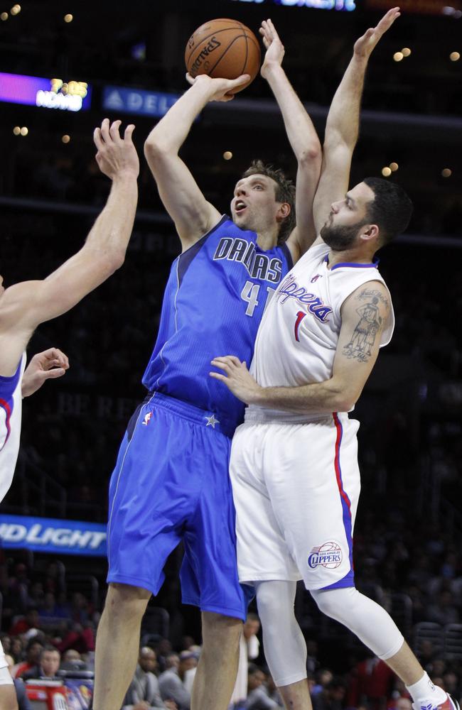 Dallas Mavericks forward Dirk Nowitzki, of Germany, is fouled by Los Angeles Clippers guard Jordan Farmar.