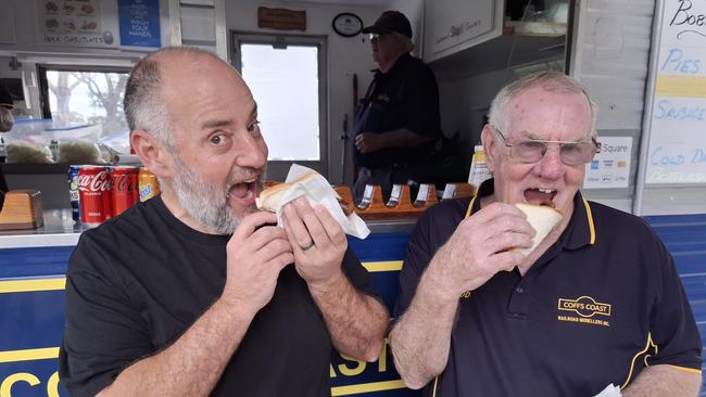 Aaron Ayton and Bob Wilkins enjoy a democracy sausage on Saturday. Picture: Toni Moon