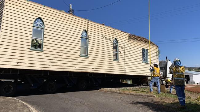 Energex crews hold up a powerline while the church on the back of a tow truck was removed from Beechmont Road onto its permanent Lower Beechmont property. Photo: Emily Halloran