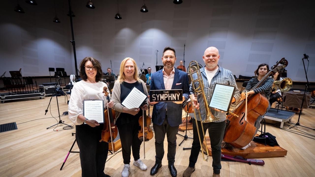 TasPlates CEO David McGrath (second from right in the front) with TSO musicians (from left to right) Anna Larsen Roach, Lucy Carrig-Jones and David Robins (with Aurora Henrich on double bass (right) and other musicians in the background. Picture Caleb Miller.