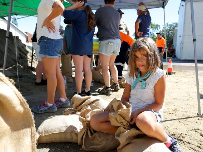 Annabelle Smith, 8, helps tie up sandbags in Maclean. Picture: Toby Zerna