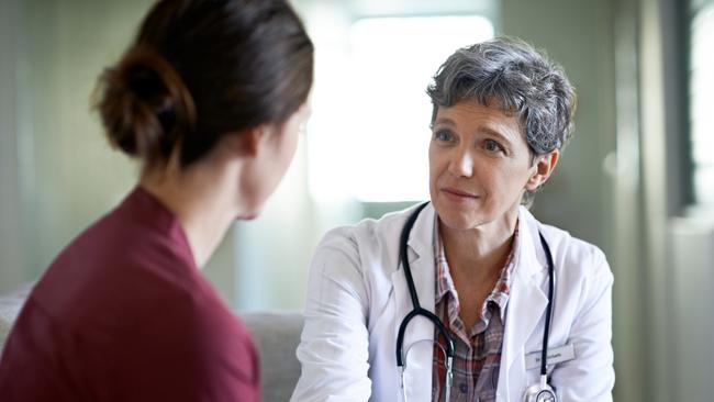 Shot of a compassionate doctor comforting a young woman in a hospital waiting room; fear health scare generic