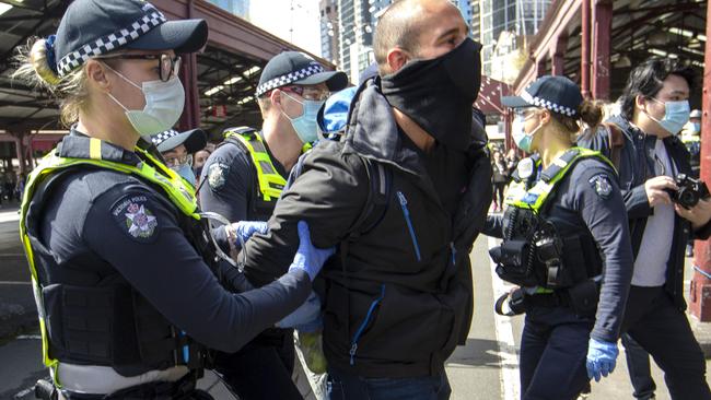 Police arrest a protester at a Melbourne Freedom Walk at Queen Victoria Market on Sunday. Picture: NCA NewsWire / David Geraghty