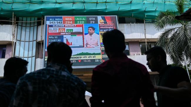 Pedestrians watch share prices on a digital broadcast outside the Bombay Stock on the day of the general election. Picture: Punit Paranjpe/AFP