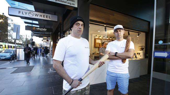 Flywheel Bakery co-owners Anthony Abazis and Antony Wallace, on Flinders Street have been forced to trade baguettes for baseball bats. Picture: David Caird