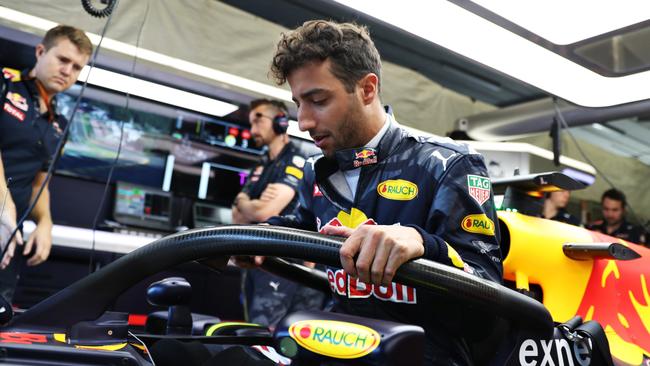Daniel Ricciardo of Australia and Red Bull Racing climbs into his car fitted with the halo.