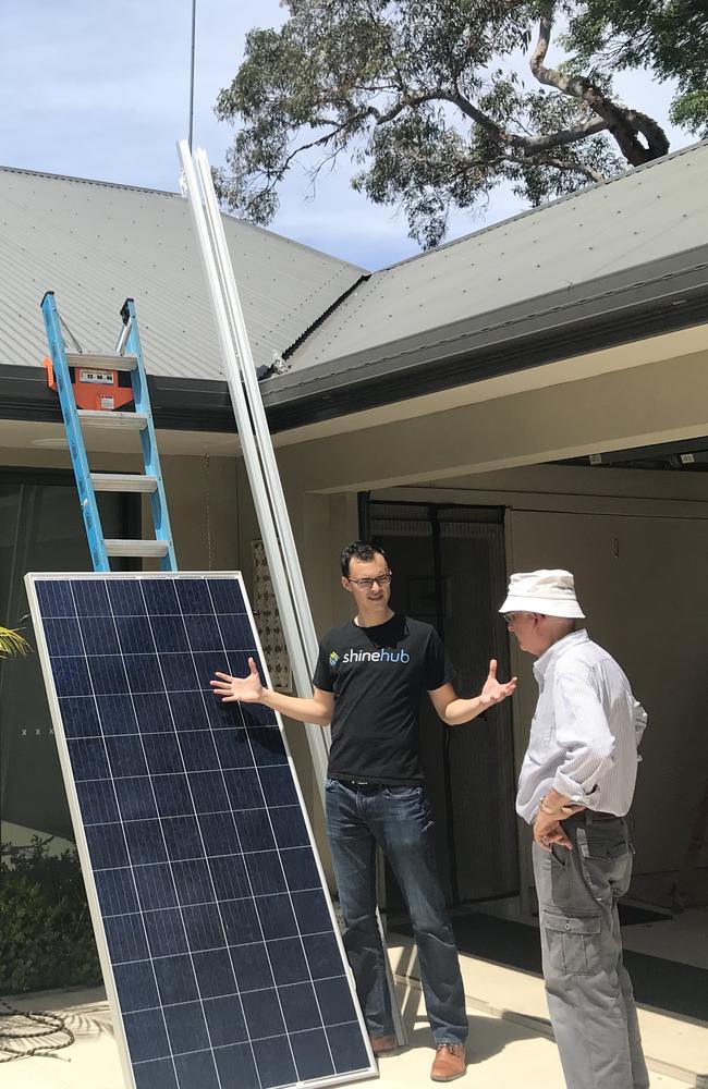 ShineHub’s Alex Georgiou with Michael Peters during the installation of his solar panels.