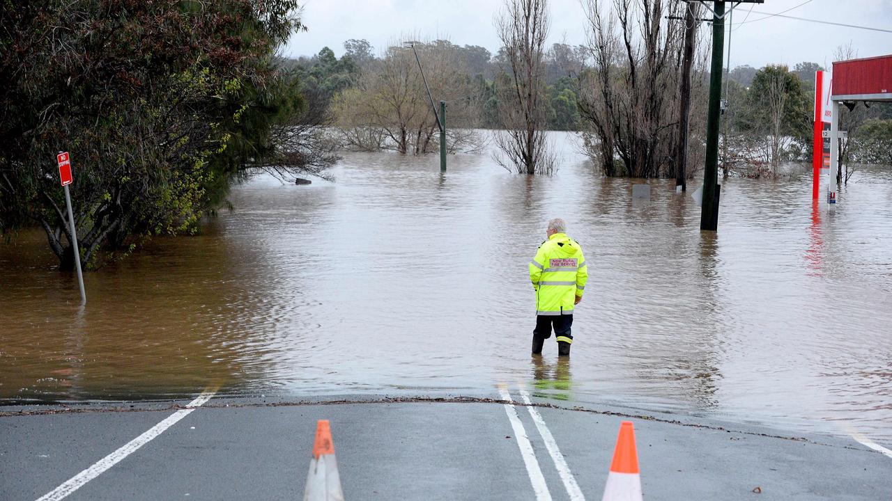 A rescue worker examines a flooded area due to torrential rain in the Camden suburb of Sydney. Pivyutr: Muhammad Farooq/AFP