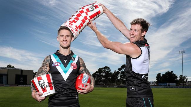 Port Adelaide's Hamish Hartlett and captain Tom Jonas with KFC buckets to promote their new sponsor, which was announced in December. Picture: Sarah Reed