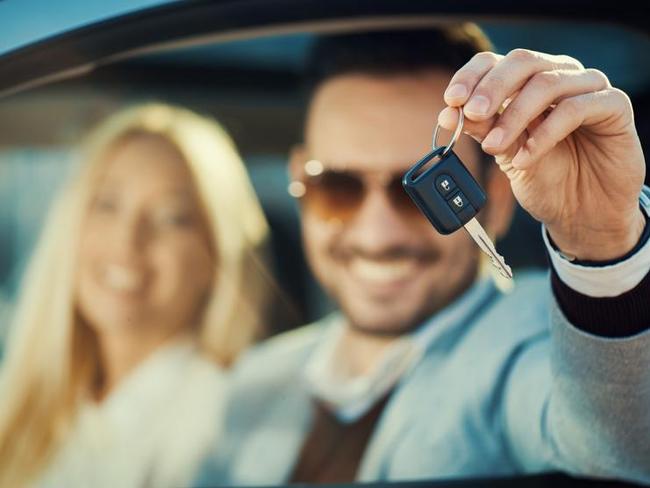 Man and woman buying a car.Men sitting in a car and showing car key. Focus on key.