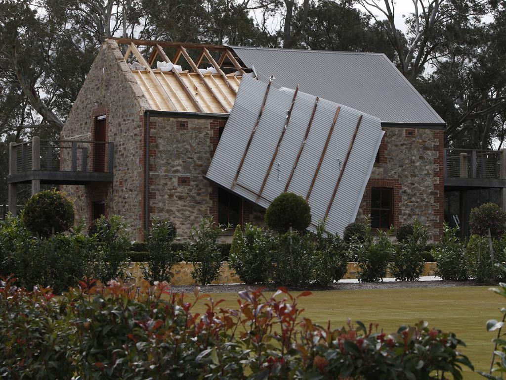 A roof, blown off by the high winds, hangs precariously on the side of a property near Nairne. Picture Simon Cross