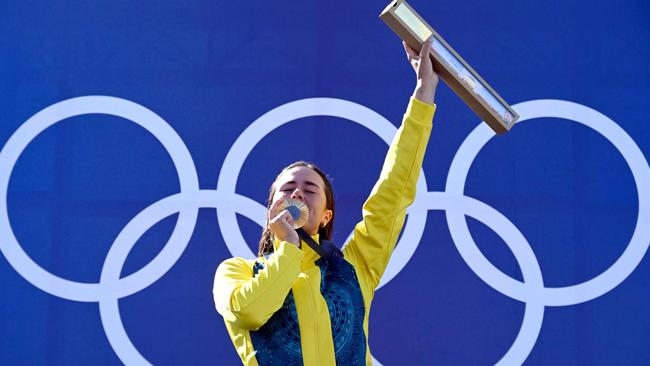 TOPSHOT - Australia's gold medallist Noemie Fox celebrates on the podium during the medal ceremony after the women's kayak cross final of the canoe slalom competition at Vaires-sur-Marne Nautical Stadium in Vaires-sur-Marne during the Paris 2024 Olympic Games on August 5, 2024. (Photo by Olivier MORIN / AFP)