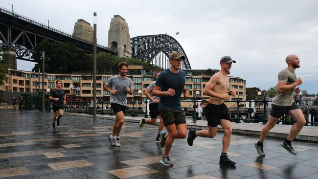 Sydneysiders are seen jogging along the esplanade near the Park Hyatt Hotel in the Rocks as more grey cloudy skies and rain is set to hit the city on Friday. Picture: NCA Newswire / Gaye Gerard