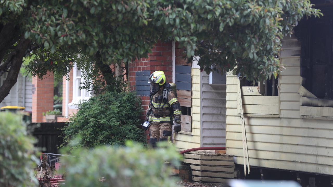 A firefighter leaves the house. Picture: Alan Barber