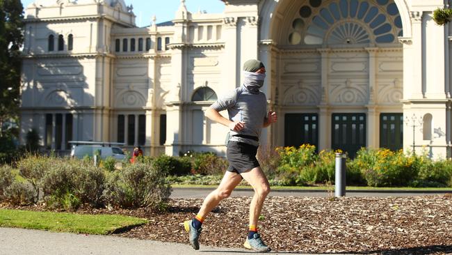 A man dons a mask for his run at the Carlton Gardens. Picture: Robert Cianflone/Getty Images