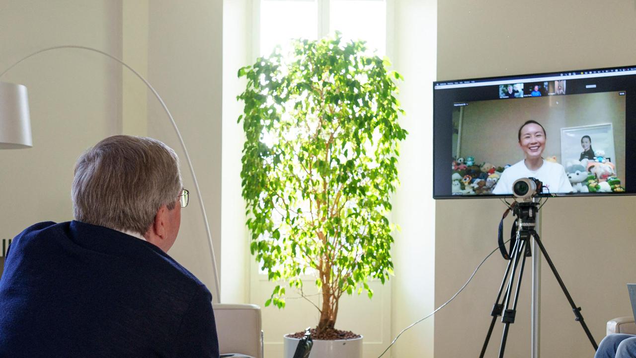 A photo of Bach speaking with Shuai. Photo by Greg MARTIN / OIS/IOC / AFP