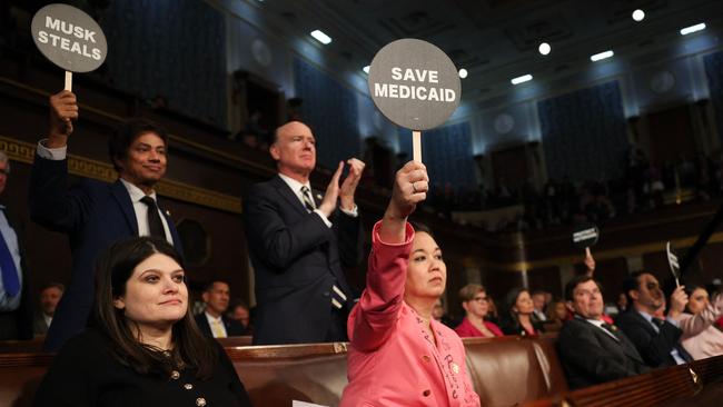 Jill Tokuda holds a protest sign with fellow Democrats as Mr Trump addresses a joint session of Congress. Picture: Win McNamee/Getty Images/AFP