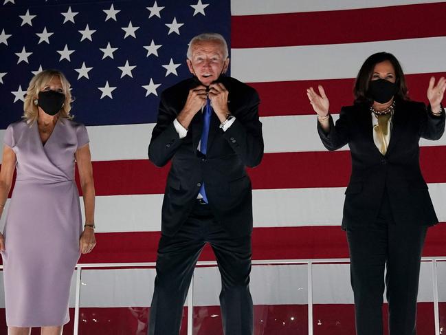 Former vice-president and Democratic presidential nominee Joe Biden briefly removes his mask as he greets supporters alond with his wife Jill Biden and Senator from California and Democratic vice presidential nominee Kamala Harris outside the Chase Center in Wilmington, Delaware, at the conclusion of the Democratic National Convention, held virtually amid the novel coronavirus pandemic, on August 20, 2020. (Photo by Olivier DOULIERY / AFP)