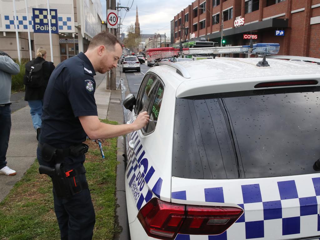 A police officer writes a slogan on a vehicle at Richmond station on Thursday. Picture: David Crosling