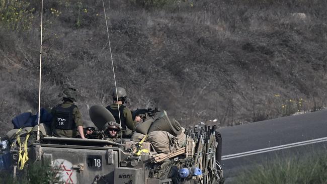 Israeli soldiers ride an armoured vehicle along a road on the outskirts of the southern Israeli city of Sderot on October 28. Picture: AFP