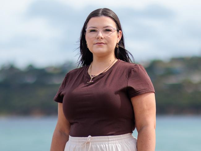 Melbourne, Victoria - January 22, 2025: Pictured on Safety beach. Katie Elson was 26 when her partner noticed a lump in her breast. They thought it was an ingrown hair. A GP said it "doesn't feel too nasty" and told her she was too young to have breast cancer. She was told she could get it checked out but Medicare wouldn't cover it. Katie paid $1000 for a mammogram, ultrasound and biopsy, discovering cancer. She has since had several surgeries including a double mastectomy and reconstruction. Katie later discovered the cancer had spread to her pelvis, and requ ired chemo and radiation. She will be on drugs for life. She is not eligible for PBS support for the drubs because she is too young and doesn't have kids.Her out of pocket costs are well over $50k.Picture: The Australian / Nadir Kinani