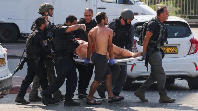 Members of Israeli security forces carry an injured person on a stretcher following a rocket attack from the Gaza Strip in Ashkelon, southern Israel, on October 7, 2023. Picture: Ahmad Gharabli/AFP