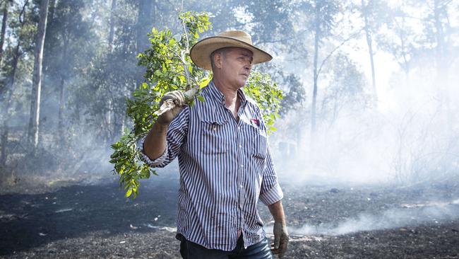 Cattle farmer David Callaughan fights a fire on his property at Possum Brush, south of Taree. Picture: John Feder