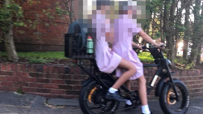 Secondary school students, without helmets, riding an e-bike on a footpath at Queenscliff. Picture: Jim O'Rourke