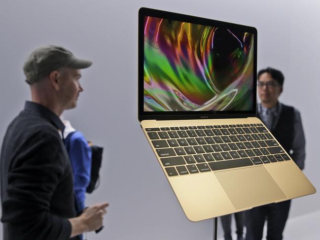 FILE - In this March 9, 2015 file photo, members of the media and Apple guests get a look at the new MacBook in the demo room after an Apple event in San Francisco. The company will debut the new laptop on Friday, April 10, 2015. (AP Photo/Eric Risberg, File)