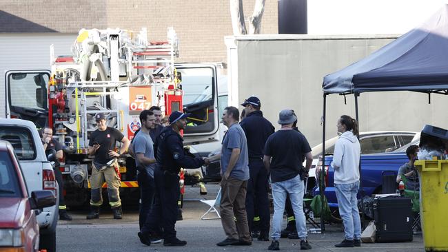 Firefighters and detectives at crime scene in a business on the corner of Milperra Road and Queen Street at Milperra. Picture: Richard Dobson