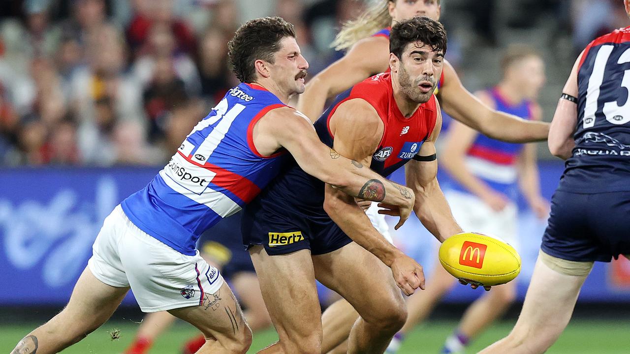 MELBOURNE, MARCH 16, 2022: Round one opening match of the 2022 AFL season - Melbourne v Western Bulldogs at the MCG. Christian Petracca of the Demons under pressure from Tom Liberatore of the Bulldogs. Picture: Mark Stewart