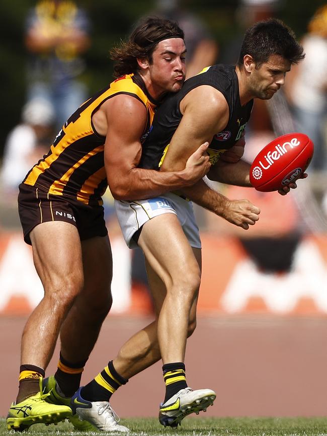 Young Hawk Jai Newcombe tackles Trent Cotchin. Picture: Dylan Burns/AFL Photos