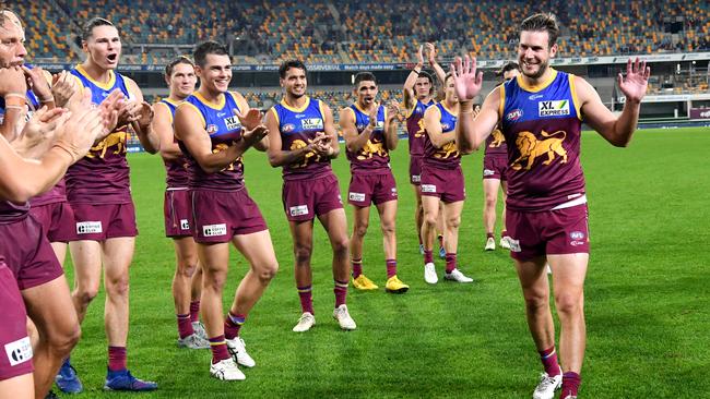 Grant Birchall (right) of the Lions is seen being cheered on by teammates after playing his 250th AFL match during the Round 3 AFL match between the Brisbane Lions and the West Coast Eagles at The Gabba in Brisbane, Saturday, June 20, 2020. (AAP Image/Darren England)