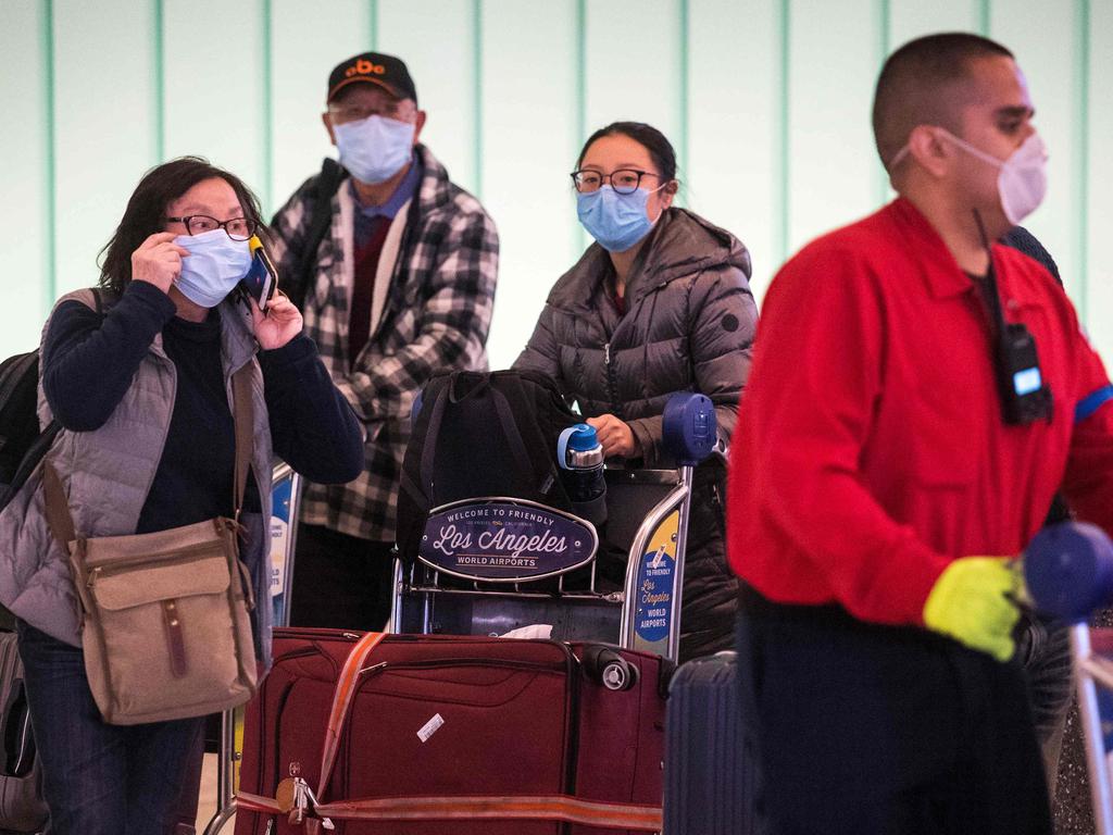 Passengers wear face masks to protect against the spread of coronavirus as they arrive on a flight from Asia at Los Angeles International Airport. Picture: Mark Ralston/AFP