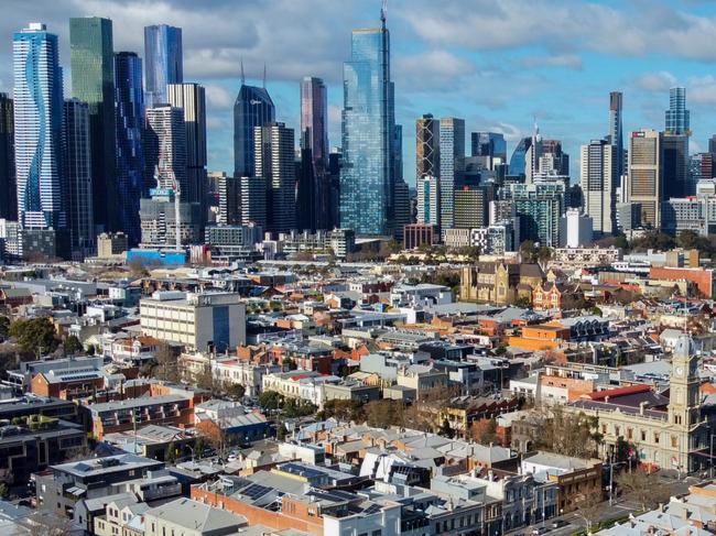 Aerial view of houses and apartments in popular inner city suburb of North Melbourne, looking towards the Melbourne city skyline.