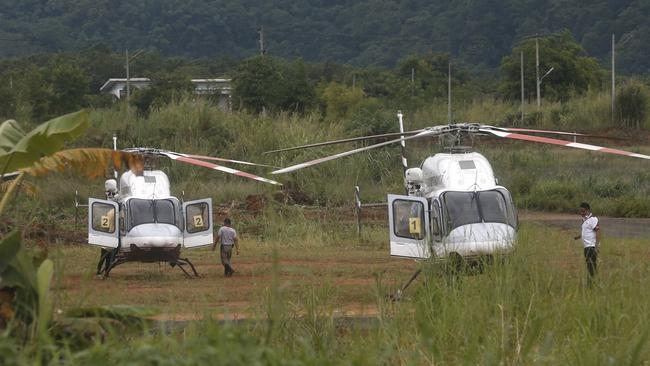 Two helicopters wait near the cave for more evacuations of the boys and their soccer coach. Picture: AP