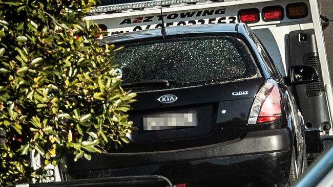 A car with a shattered back window is towed from the scene on Saturday. Picture: Julian Andrews