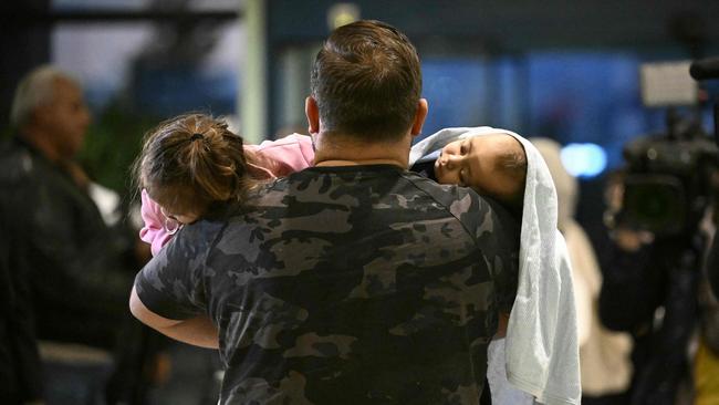 A man carries two children after arriving at Sofia airport on a Bulgarian government evacuation flight from Lebanon on Monday. Picture: AFP