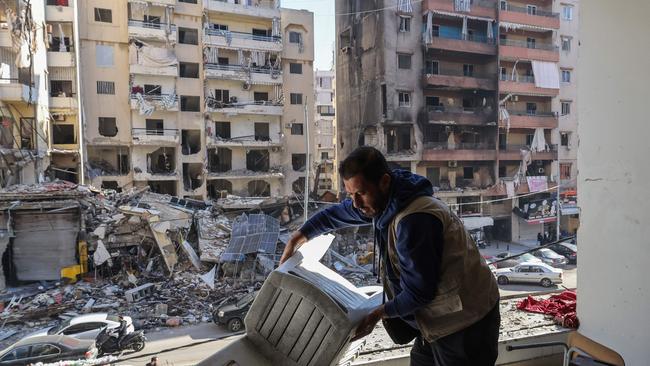 A staff member of a Lebanese non-governmental organisation salvages items at its branch that was damaged in an Israeli strike on a nearby building in Beirut on Monday. Picture: AFP