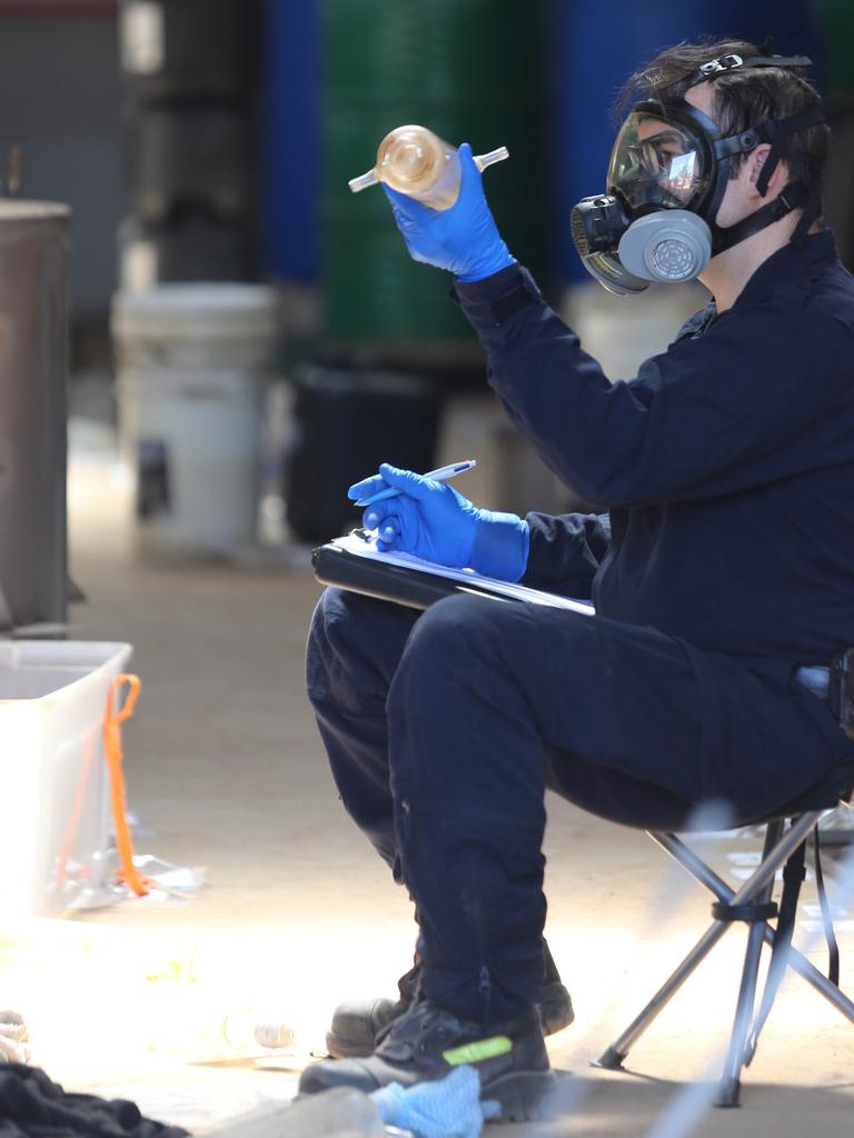 A police officer examines a piece of equipment found in the drug lab. Picture: NSW Police
