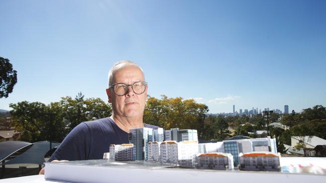 Architect Lester Ehrlich with a cardboard scale model he made of the original Tricare proposal. The view behind him could now be permanently blocked by massive concrete walls. Picture: AAP/Ric Frearson