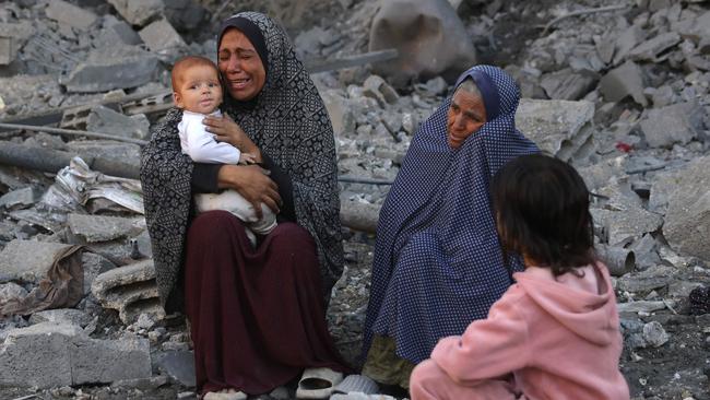 A woman holding a baby cries as Palestinians check the site of an overnight Israeli strike in Jabalia in the central Gaza Strip. Picture: Bashar Taleb / AFP