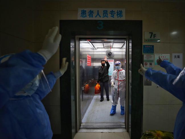 Medical staff wave goodbye to a recovered COVID-19 coronavirus patient at the Red Cross Hospital in Wuhan.