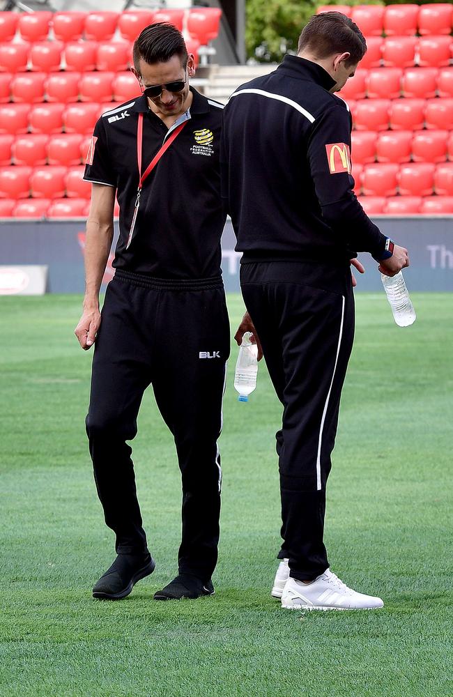 Match officials inspect the pitch at Coopers Stadium, Hindmarsh.