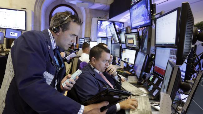 Trader Gregory Rowe, left, works with colleagues on the floor of the New York Stock Exchange. (AP Photo/Richard Drew)