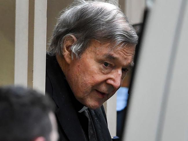 Australian Cardinal George Pell (C) is escorted in handcuffs from the Supreme Court of Victoria in Melbourne on August 21, 2019. - Disgraced Catholic Cardinal George Pell was sent back to jail after an Australian court rejected his landmark appeal against convictions for child sex abuse. (Photo by William WEST / AFP)