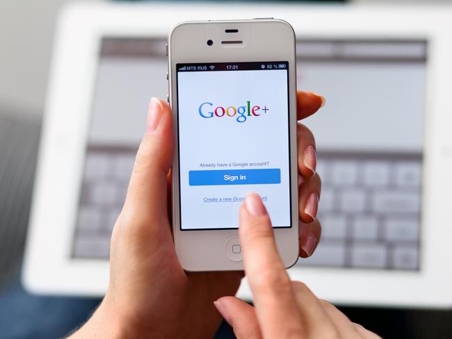 Nizhnevartovsk, Russia - March 11, 2013: Woman hand holding iPhone with Google Plus App and using tPad. Google Inc. is an American multinational corporation that provides Internet-related products and services, including internet search, cloud computing, software and advertising technologies.